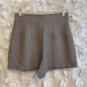 Contrived clash juniors shorts. Black and white houndstooth pattern. Zip up.